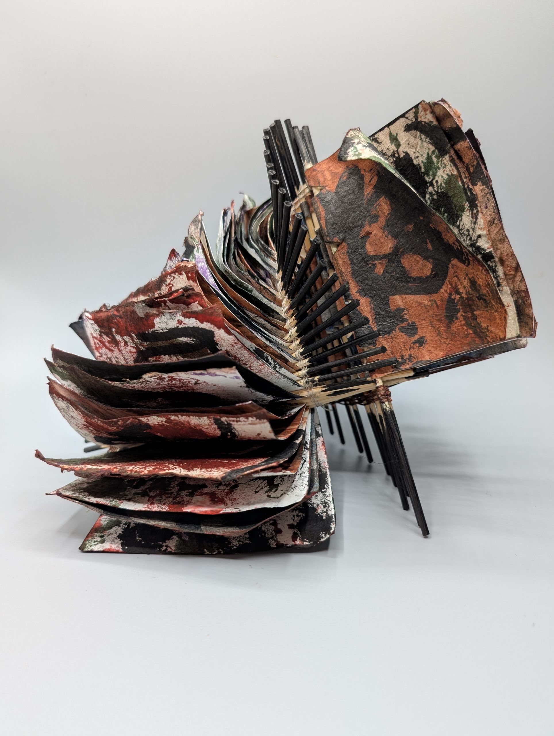 Image is of an accordion book with purple and red covers. 