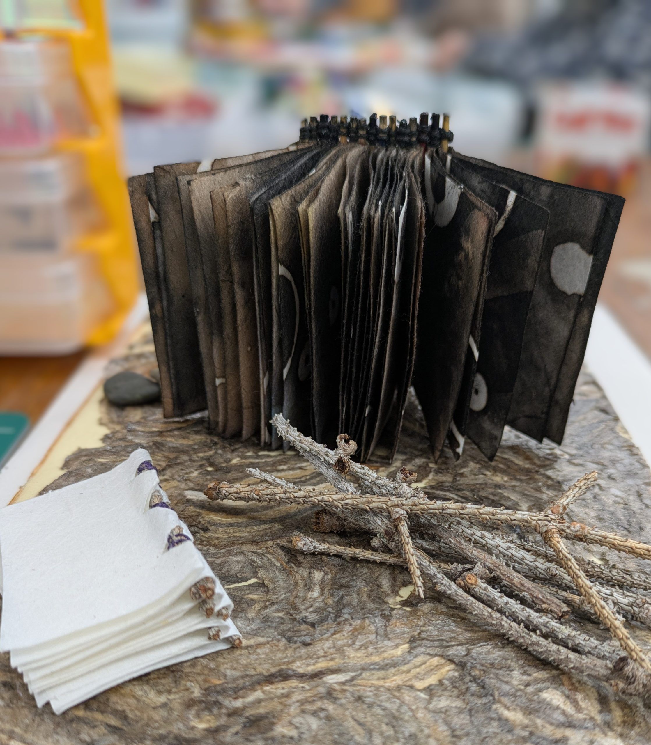 Image is of an accordion book with purple and red covers. 